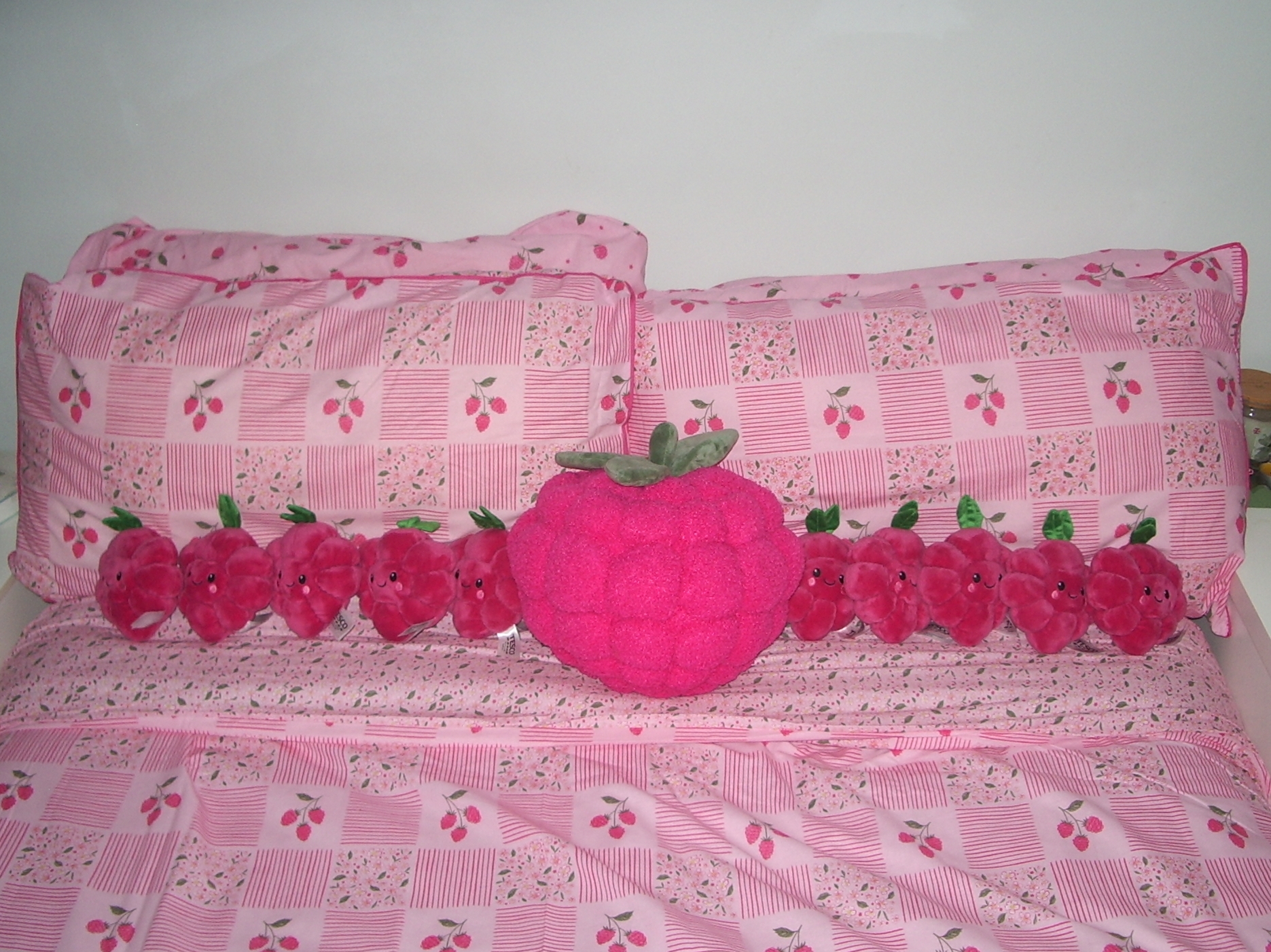well there’s a big plushy raspberry and then a bunch of smaller ones arranged on a bed with raspberry-themed sheets and pillows, which in my humble opinion is pretty funny and i refuse to explain why this was done. fuck you